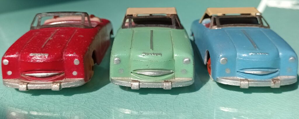 vue de face de mes trois premières Panhard Dyna junior CIJ : une rouge, une vert clair, une bleu clair avec entourage du pare-brise chromé