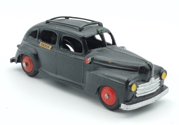 Vue de 3/4 d'une Ford Super Deluxe 1946 Fordor noire Tekno en version Taxa appliqué sur les portes arrières mate sur le dessusplus brillante sur les côtés