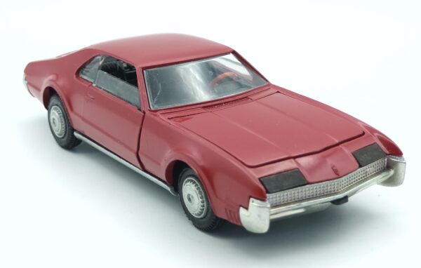 Vue de 3/4 avant d'une Oldsmobile Toronado 1967 rouge reproduite par Tekno dès 1969 à l'échelle 1/43