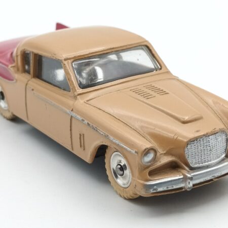 Vue de 3/4 avant de la Studebaker Golden Hawk Dinky Toys GB biclore café au lait et rouge framboise avec roues en aluminium