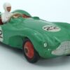 Vue de 3/4 avant d'une Aston Martin DB3S/4 de 1953reproduite par Dinky Toys GB verte avec numéros de course, son châssis est oxydé, des traces d'humidité sur la peinture rouge des roues, les numéros ont des petits manques