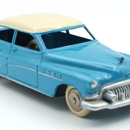 Vue de 3/4 avant d'une Buick Roadmaster 1952 berline Dinky Toys France 24V bleue à toit crème avec intérieur du toit quadrillé, roues chromées avec boite en état moyen sans ombre conforme au modèle