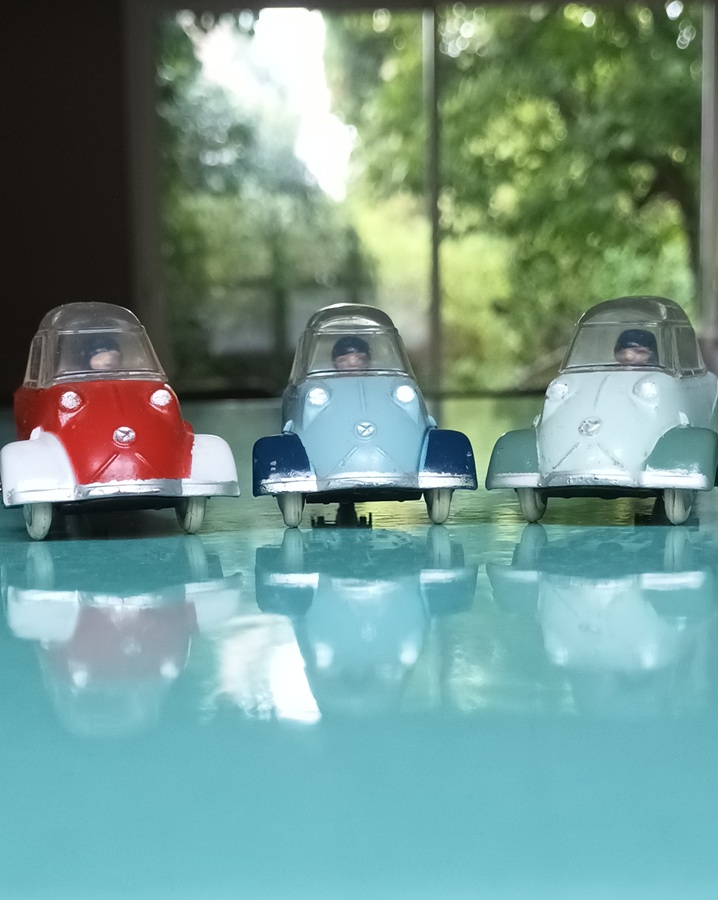 Trois Messerschmitt KR 200 Quiralu bicolores de face en éventail; rouge/blanc, bleu clair/ bleu soutenu, vert d'eau/ vert gris