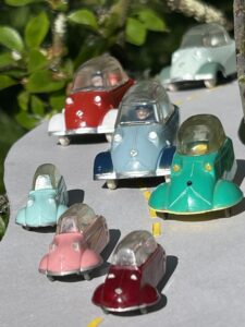 De face en descente dans un "s" 1 Messerschmitt Siku ( une type 1 bordeaux) suivie de 2 Messerschmitt Siku de type 2( 1 rose, 1 bleu clair) 1 messerschmitt JUNO Plast verte puis 3 Messerschmitt Quiralu ( 1 bleue, 1 rouge, vert d'eau
