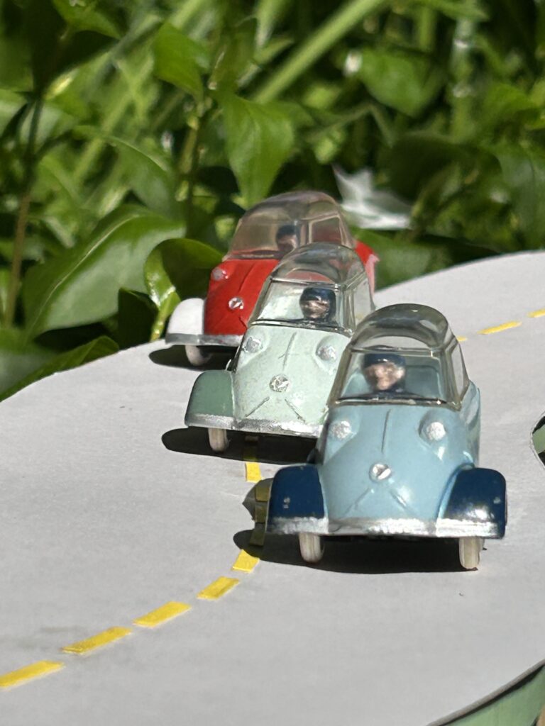 Trois Messerschmitt KR 200 Quiralu Bicolores se suivant  sur une route, 1 bleu,1 verte, 1 rouge