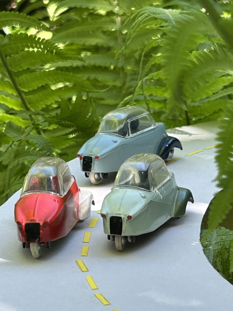 Vue arrière de trois Messerchmitt KR 200 Quiralu dans virage bordé de fougères